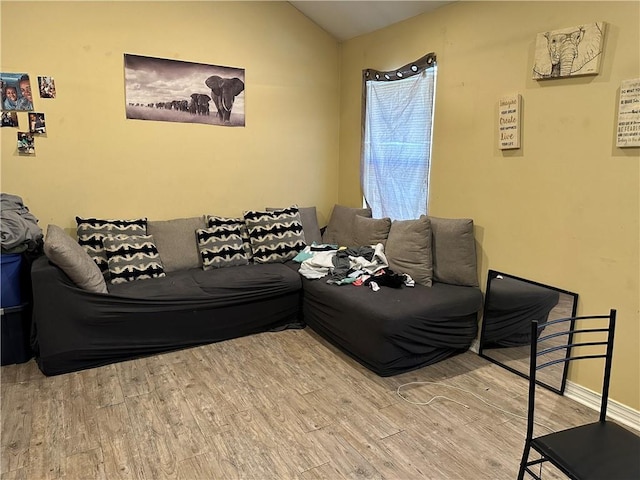 living room featuring lofted ceiling and hardwood / wood-style floors