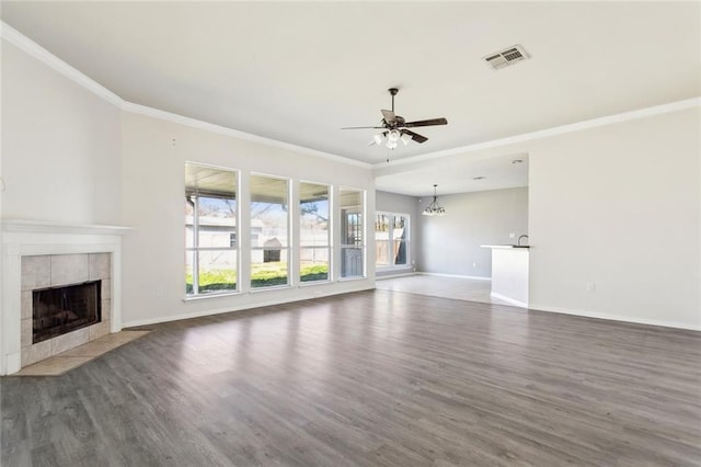 unfurnished living room featuring ornamental molding, dark hardwood / wood-style floors, ceiling fan with notable chandelier, and a fireplace