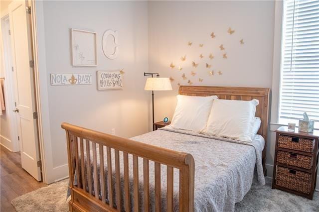 bedroom with multiple windows and hardwood / wood-style floors