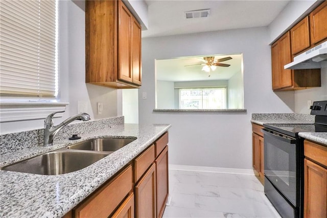 kitchen featuring ceiling fan, sink, electric range, and light stone counters