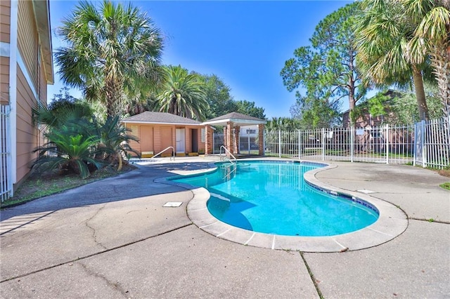 view of swimming pool with an outbuilding and a patio