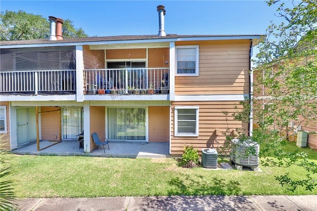 rear view of house with a lawn, central air condition unit, and a patio area