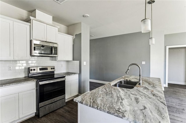 kitchen with sink, white cabinetry, hanging light fixtures, stainless steel appliances, and light stone counters