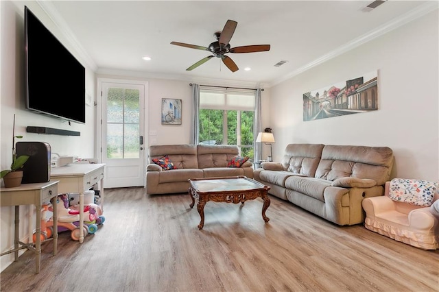 living room featuring ornamental molding, light hardwood / wood-style flooring, and a wealth of natural light