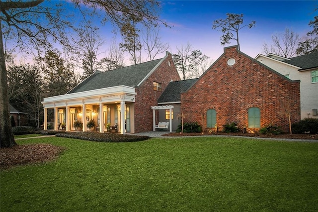 view of front facade with a front yard and brick siding