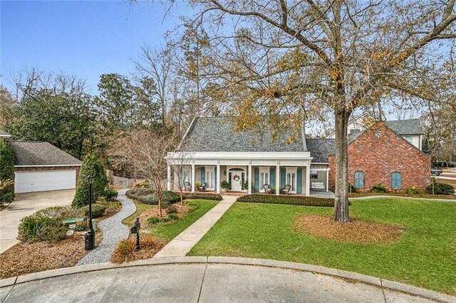 view of front of property with an outbuilding, a garage, a front yard, and covered porch