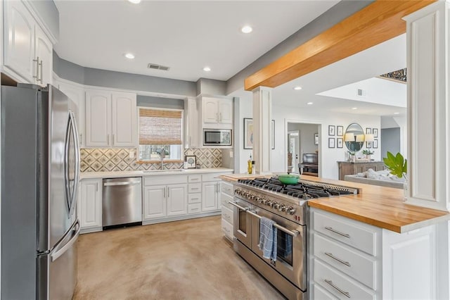 kitchen featuring visible vents, white cabinets, wood counters, appliances with stainless steel finishes, and a sink