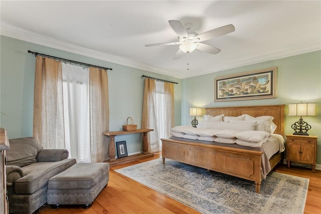 bedroom with crown molding, multiple windows, ceiling fan, and wood finished floors