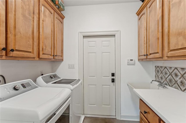 laundry area featuring cabinet space, a sink, and separate washer and dryer