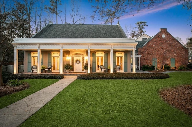 view of front of house with a yard, stucco siding, and a patio