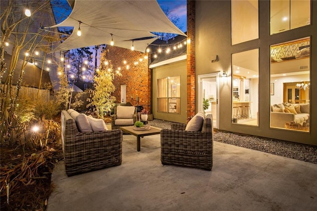 patio terrace at dusk featuring outdoor lounge area and visible vents