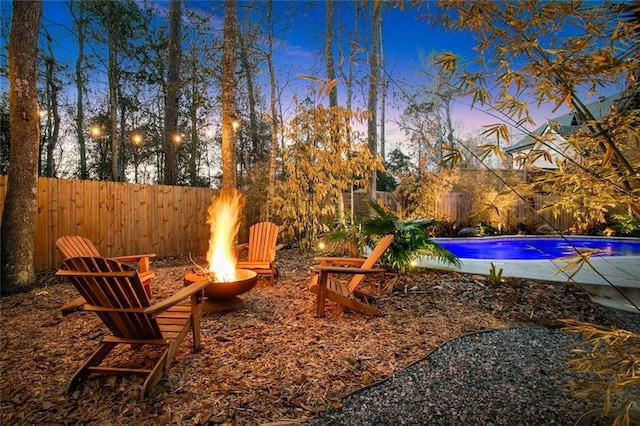 view of yard with an outdoor fire pit, a fenced backyard, and a fenced in pool