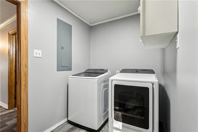 washroom featuring hardwood / wood-style flooring, crown molding, washing machine and clothes dryer, and electric panel