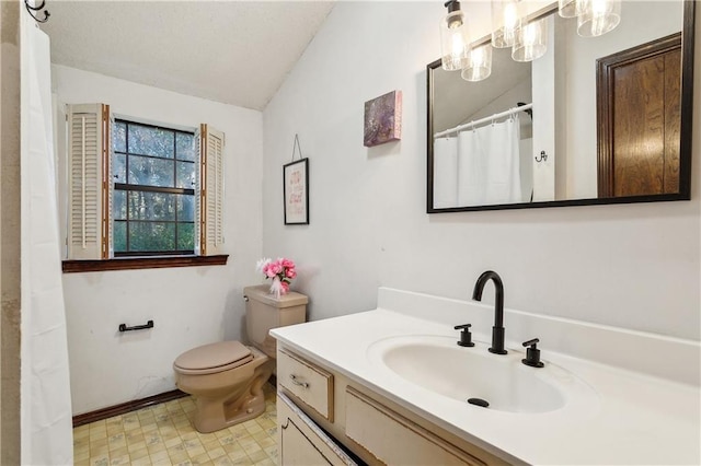 bathroom with lofted ceiling, toilet, and vanity