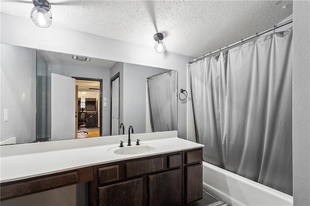 bathroom featuring vanity, a textured ceiling, and shower / bath combo with shower curtain