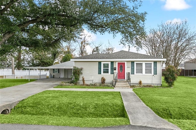 view of front of property featuring a shingled roof, fence, concrete driveway, a front yard, and a carport