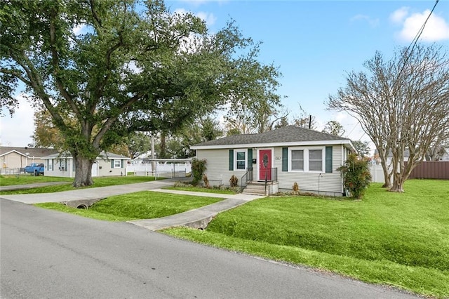 view of front of home featuring concrete driveway, a front lawn, and fence