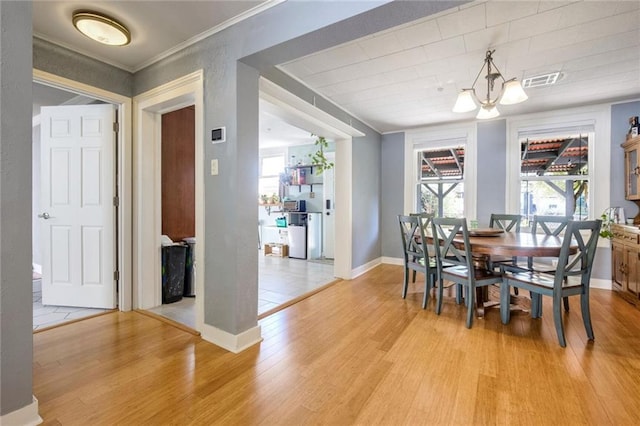 dining area featuring light hardwood / wood-style flooring and ornamental molding