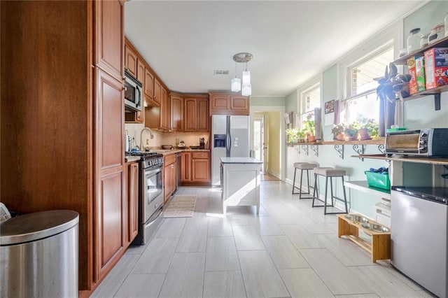 kitchen with hanging light fixtures and stainless steel appliances