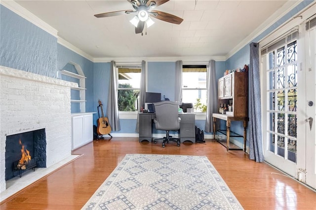 office area with hardwood / wood-style floors, a fireplace, ornamental molding, and ceiling fan