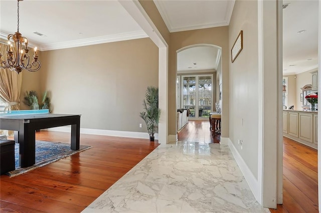 hall featuring crown molding, hardwood / wood-style flooring, and a notable chandelier