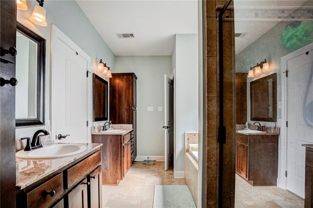 bathroom featuring tiled tub and vanity