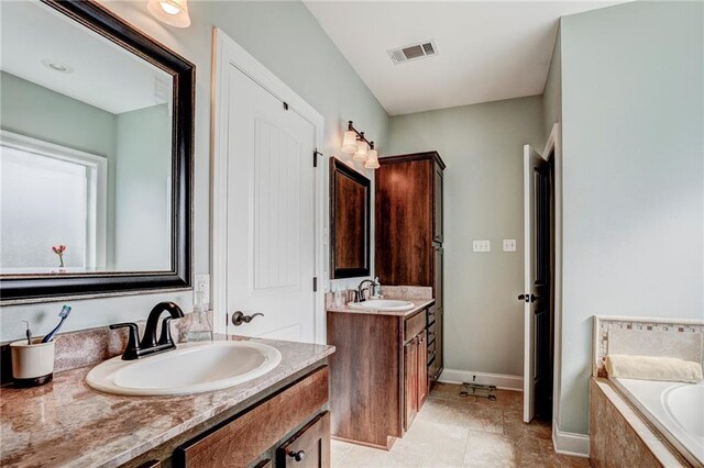 bathroom featuring vanity and tiled bath