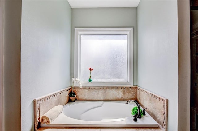 bathroom with a relaxing tiled tub and plenty of natural light