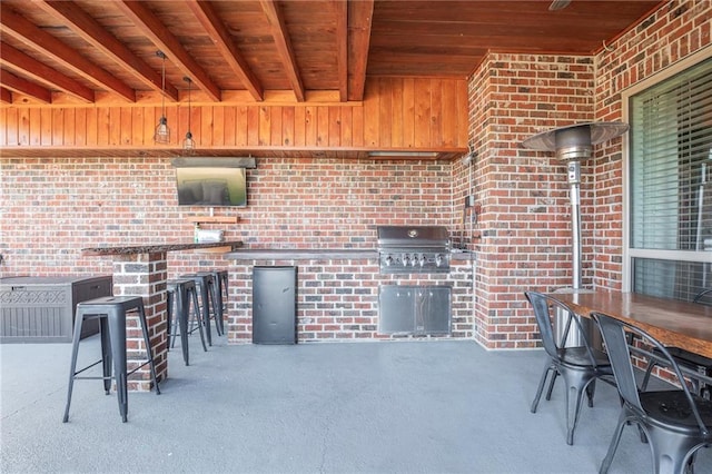 view of patio / terrace with exterior bar and a grill