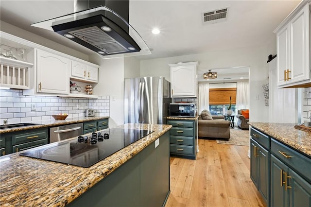 kitchen featuring tasteful backsplash, light stone counters, light hardwood / wood-style flooring, appliances with stainless steel finishes, and white cabinets