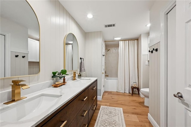 full bathroom with shower / bath combination with curtain, wood-type flooring, toilet, and vanity