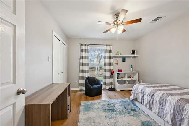 bedroom with a closet, ceiling fan, and light wood-type flooring