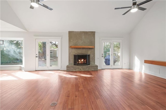 unfurnished living room with a fireplace, light hardwood / wood-style floors, ceiling fan, and plenty of natural light