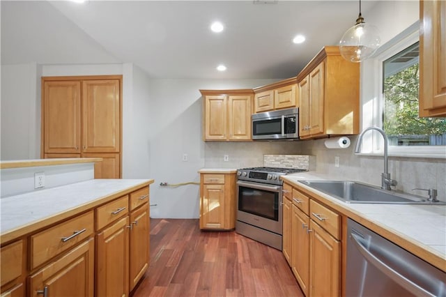 kitchen featuring sink, tasteful backsplash, appliances with stainless steel finishes, dark hardwood / wood-style floors, and pendant lighting