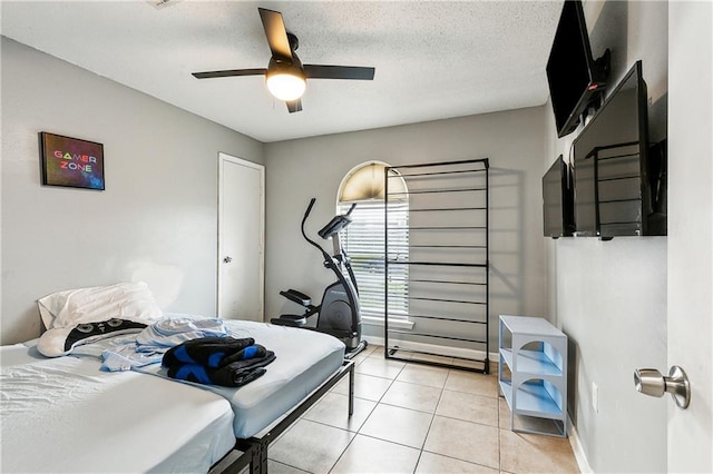 bedroom featuring ceiling fan, a textured ceiling, and light tile patterned flooring