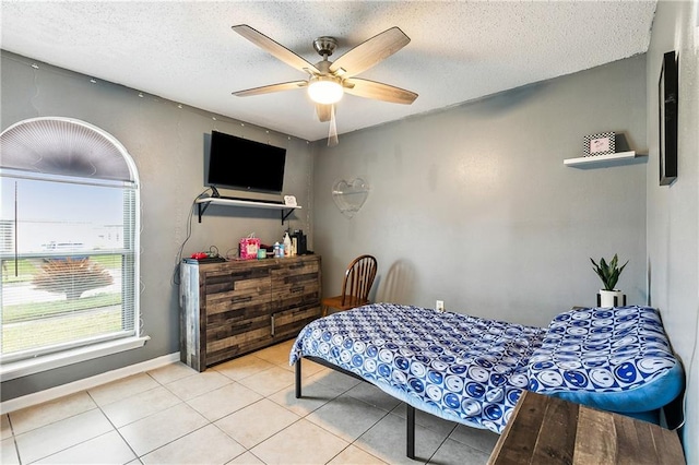 bedroom featuring ceiling fan, a textured ceiling, and light tile patterned floors