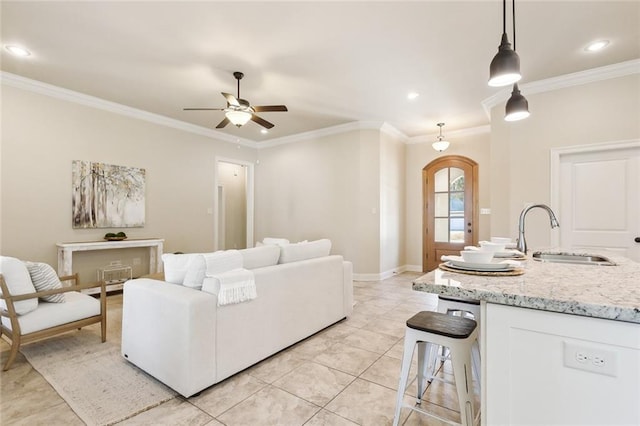 tiled living room featuring sink, ornamental molding, and ceiling fan