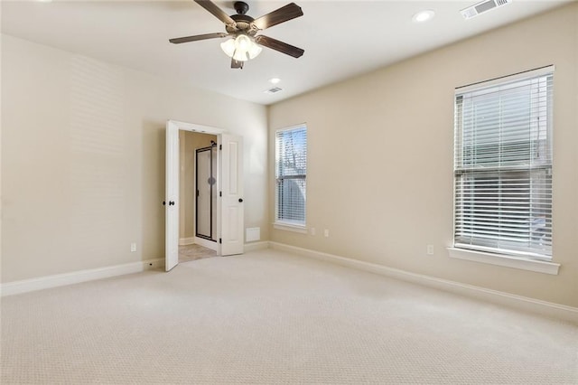 carpeted spare room featuring ceiling fan