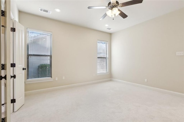 carpeted spare room featuring ceiling fan