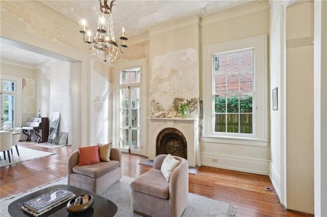 172224 Delachaise St, New Orleans, LA 70115 - living area with ornamental molding, a chandelier, wood-type flooring, and a fireplace