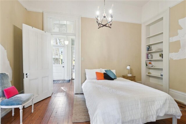 bedroom with hardwood / wood-style floors and a notable chandelier