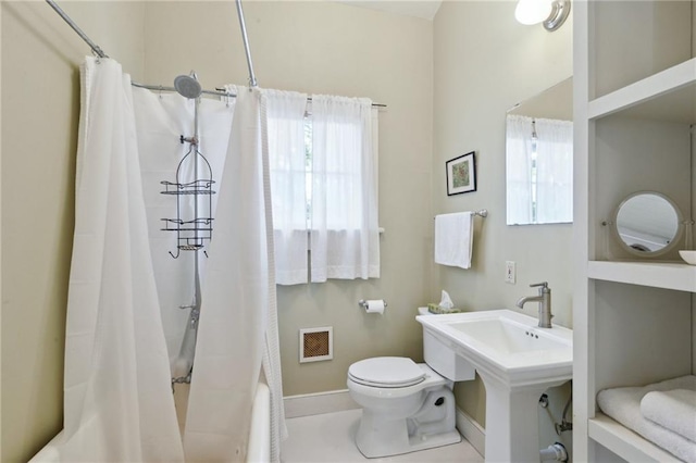 bathroom featuring shower / bath combination with curtain and toilet