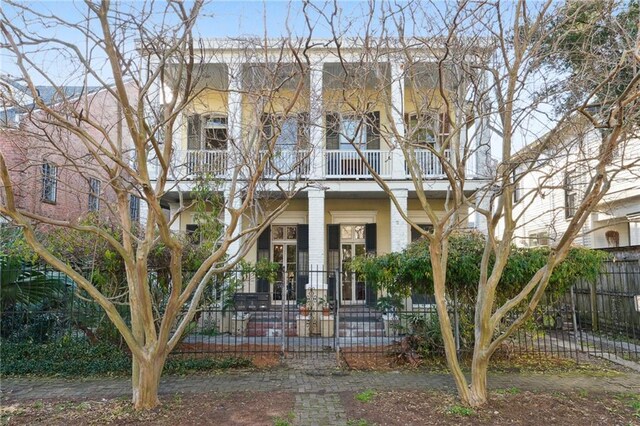 172224 Delachaise St, New Orleans, LA 70115 - view of front facade with a balcony, a fenced front yard, and brick siding