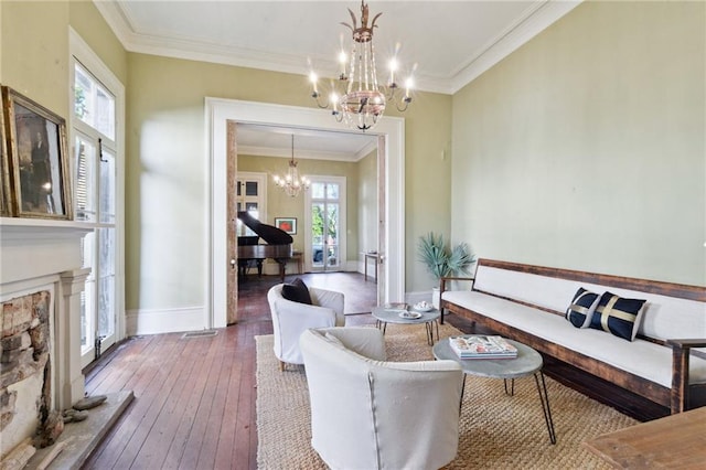 living room with a healthy amount of sunlight, hardwood / wood-style flooring, ornamental molding, and a chandelier