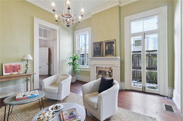 living room with crown molding, hardwood / wood-style floors, and a notable chandelier