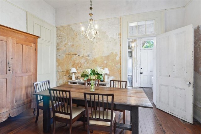 dining area with dark hardwood / wood-style flooring and a notable chandelier