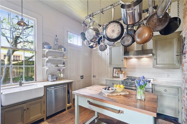 172224 Delachaise St, New Orleans, LA 70115 - kitchen featuring appliances with stainless steel finishes, a sink, wooden counters, dark wood-type flooring, and decorative light fixtures