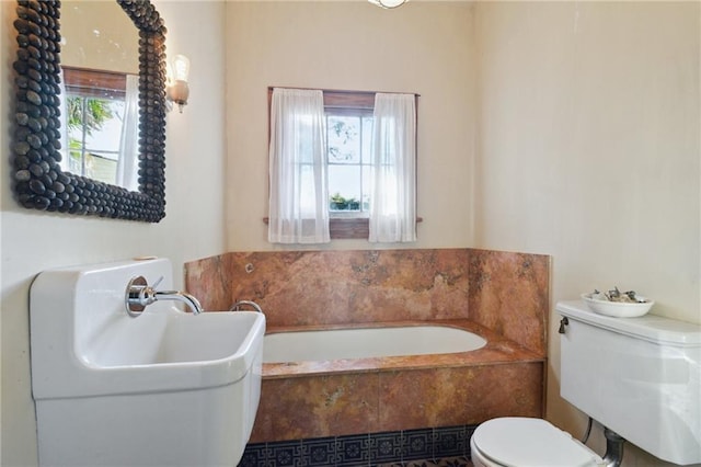 bathroom with a relaxing tiled tub and toilet