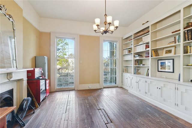 interior space featuring plenty of natural light, a notable chandelier, and dark hardwood / wood-style flooring