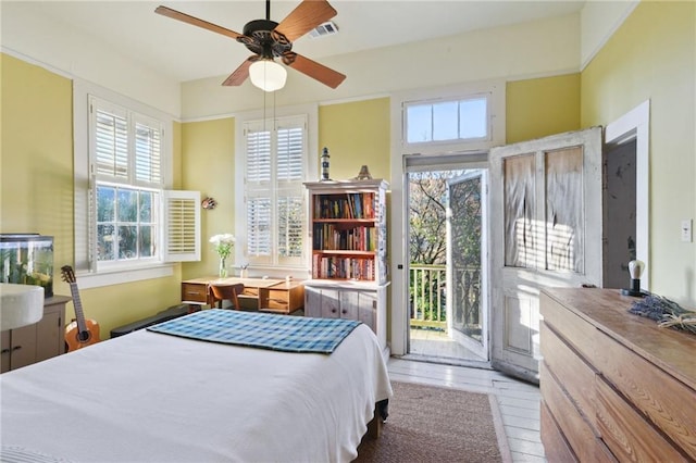 bedroom with multiple windows, access to exterior, and ceiling fan